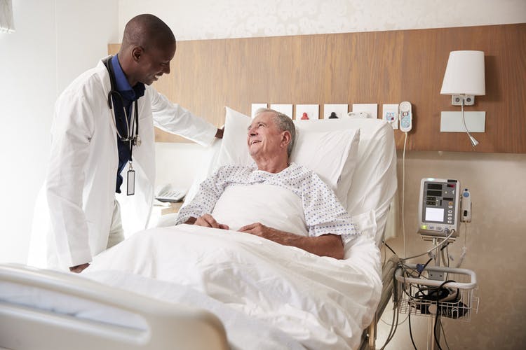 doctor helping bedridden stroke patient